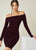 A woman wearing an off-shoulder bodycon midi dress in a wine color, paired with black boots.